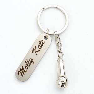 May include: Silver keychain with a silver microphone charm and a rectangular tag engraved with the name "Molly Kate".