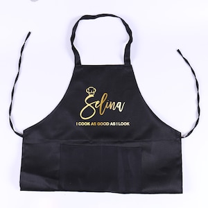 May include: Black apron with a gold  "Selina I cook as good as I look" text.