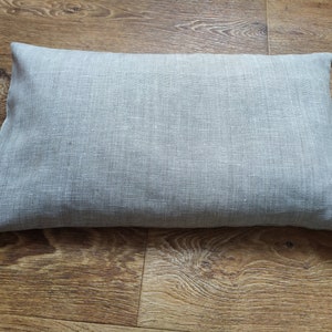 May include: A gray linen pillow with a smooth, textured surface.