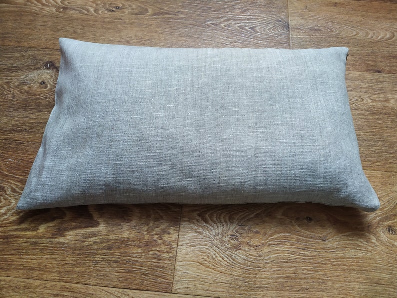 May include: A gray linen pillow with a smooth, textured surface.