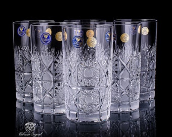May include: Set of six clear crystal glasses with intricate cut designs. Each glass features a gold and blue label with the text "Crystal Heart".