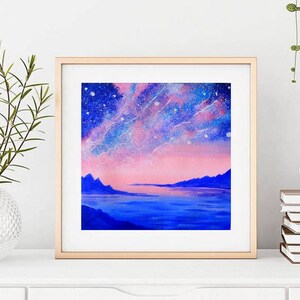 May include: A framed painting of a pink and blue landscape with a starry sky and mountains in the distance. The painting is in a light wood frame.