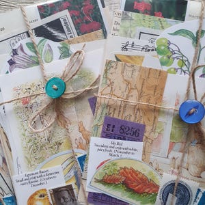 May include: A collection of vintage ephemera, including botanical illustrations, maps, and stamps, tied with twine and secured with teal and blue buttons. The assortment includes a purple ticket with the number 8256.