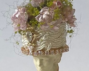 Busto di donna con cappello floreale