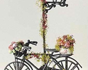 Bellissima bicicletta decorata con fiori abbinata ad una insegna da giardino