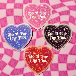 May include: Four heart-shaped stickers with the text "Do It For The Plot". The stickers are in pink, blue, red, and black, with glitter and star accents. The background is a pink and white checkered pattern.