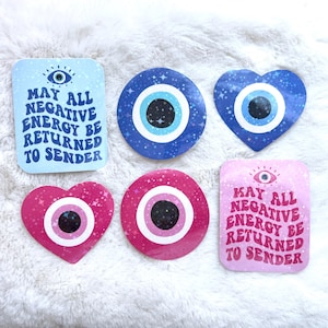 May include: Six colorful stickers with a blue evil eye design. Two stickers are rectangular with the text "May all negative energy be returned to sender". Two stickers are heart-shaped and two are round.