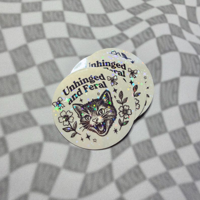 Cute meme cat vinyl sticker with sparkle holographic finish and feral quote.
