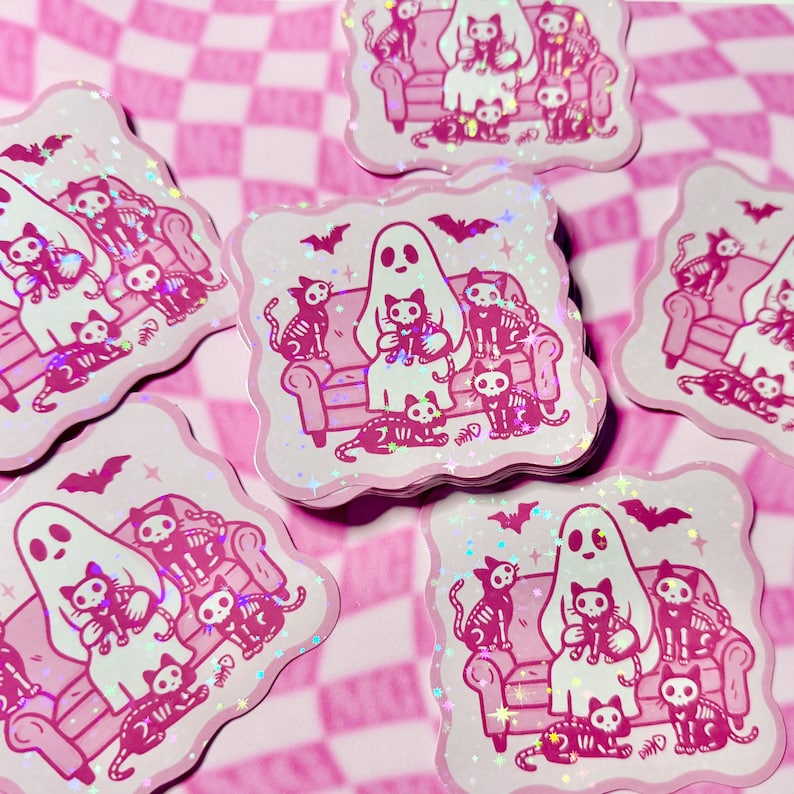 Halloween holographic spooky skeleton cat ghostie sticker with sparkly star laminate on glossy vinyl arranged randomly to show holographic effect.