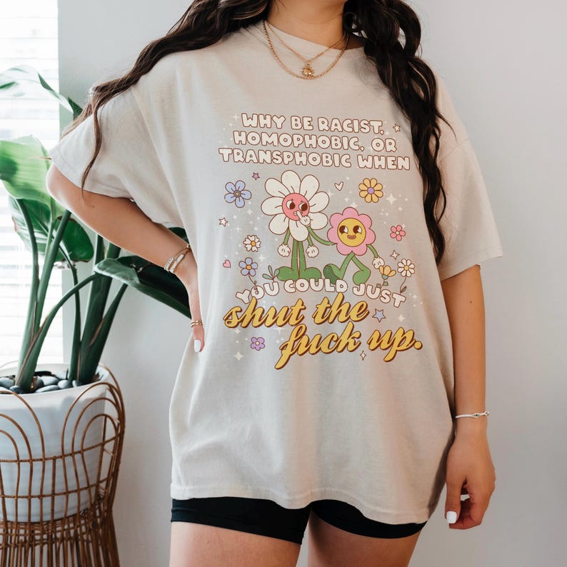 Model wearing Sand tee of why be racist, homophobic, or transphobic when you could just shut the f up tee.