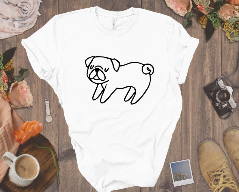May include: White t-shirt with a black line drawing of a pug dog.