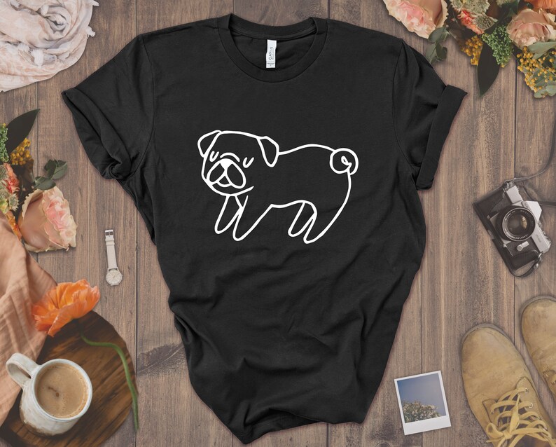 May include: Black t-shirt with a white outline drawing of a pug dog.