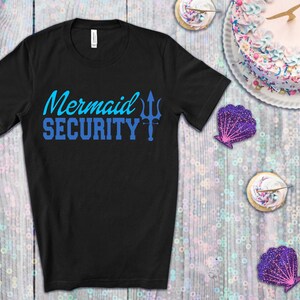 May include: Black t-shirt with blue text that reads "Mermaid Security" and a blue trident graphic.