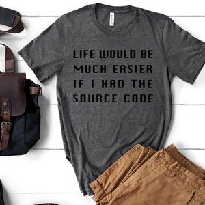 May include: A dark grey t-shirt with the text "Life would be much easier if I had the source code" printed in black.
