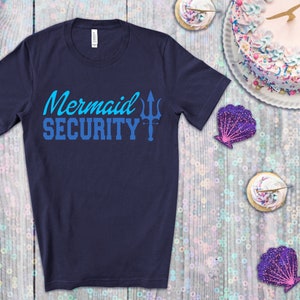 May include: A navy blue t-shirt with the text "Mermaid Security" in blue and a trident symbol.