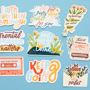 May include: Nine colorful stickers with positive affirmations and illustrations. The stickers feature phrases like "I am more than enough", "Mental Health Matters", "One day at a time", "My feelings are valid", "This is temporary", "Keep going", and "Be brave, not perfect".