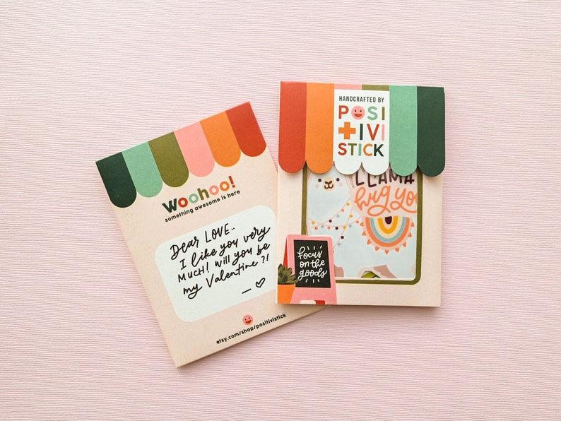 May include: Two colorful cards with a llama and a handwritten message. The llama card says "llama hug you" and the other card says "Dear Love... I like you very much! Will you be my Valentine?!". Both cards have a rainbow and a sign that says "focus on the goods".