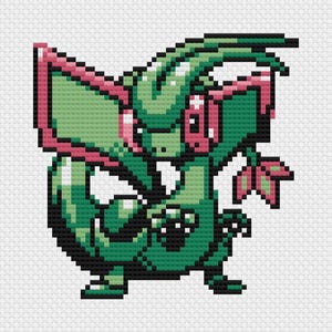 Puede incluir: Imagen pixelada de una criatura verde con detalles rosas, posiblemente un patrón de punto de cruz. La criatura tiene grandes alas, una larga cola y una expresión decidida. El diseño recuerda a los gráficos de videojuegos retro.