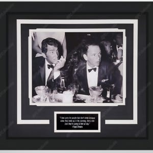 May include: Black and white framed photograph featuring Dean Martin and Frank Sinatra at a table. The photo is in a black frame with a white mat. A quote by Frank Sinatra is at the bottom.
