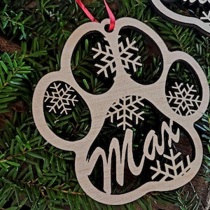 May include: Wooden paw print Christmas ornament with the name "Max" cut out and snowflake designs.