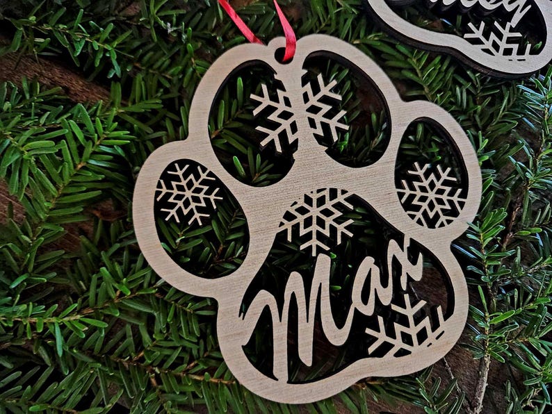 May include: Wooden paw print Christmas ornament with the name "Max" cut out and snowflake designs.