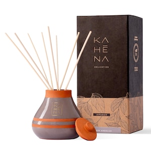 Pode incluir: Um difusor de cerâmica cinza com uma parte superior de terracota e varetas de madeira. O difusor está etiquetado com "KAHENA COLLECTION" e "DIFUSOR" na caixa. A caixa tem um fundo marrom com um padrão de folhas.