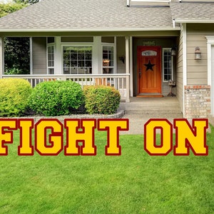 May include: A suburban home with a green lawn and a large yellow sign that reads "FIGHT ON".