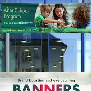 May include: A green banner with white text that reads "After School Program" and "Visit us at aschoolpgam.com". The banner also includes the text "Homework Support, Stem, Art, Drama, Sport". The banner is hanging on a glass door with a reflection of a building behind it. The banner features a photo of three children playing with building blocks.