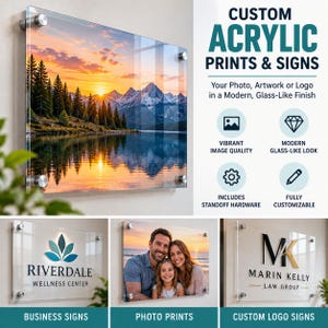 Op de afbeelding: Een rechthoekig acrylbord met een bergmeerlandschap bij zonsondergang, bevestigd met zilveren afstandhouders. De tekst luidt CUSTOM ACRYLIC PRINTS & SIGNS, RIVERDALE WELLNESS CENTER en MARIN KELLY LAW GROUP.