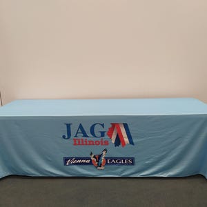 May include: A light blue table cover with the text "JAG Illinois Vienna Eagles" and a graphic of a red, white, and blue eagle with a star on its chest.