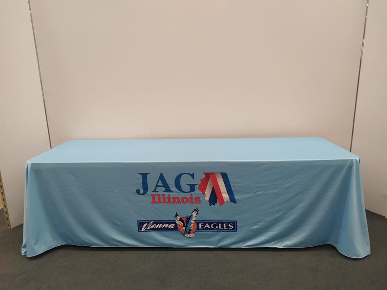 May include: A light blue table cover with the text "JAG Illinois Vienna Eagles" and a graphic of a red, white, and blue eagle with a star on its chest.