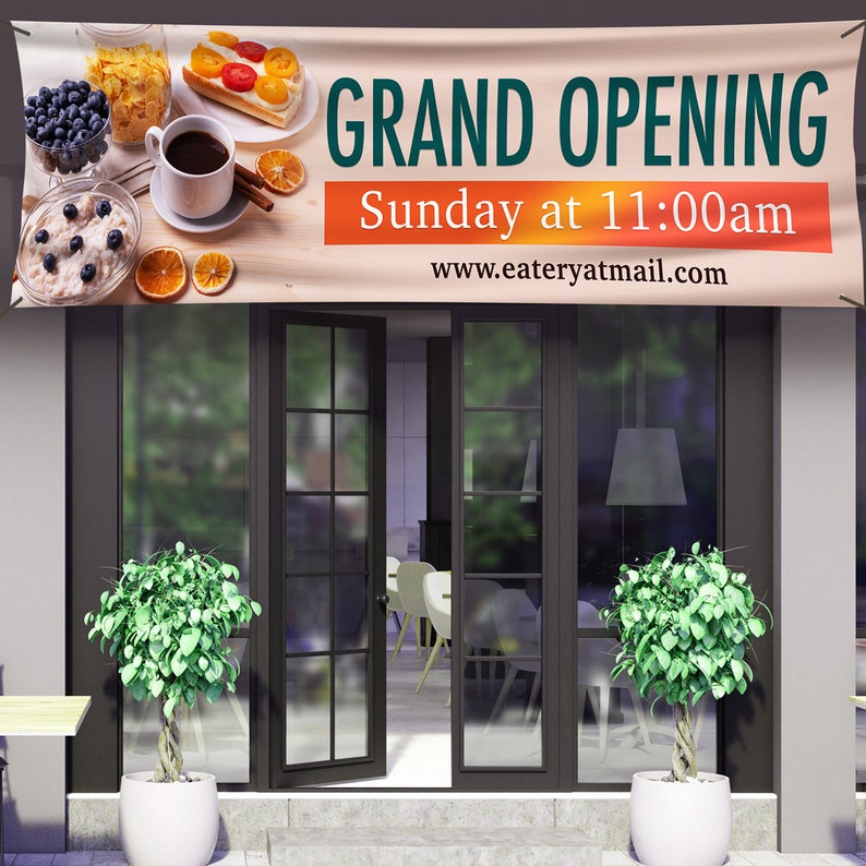 May include: A banner announcing a grand opening of a restaurant or cafe. The banner is beige with orange text and features a breakfast scene with coffee, pastries, and fruit. The text reads "Grand Opening, Sunday at 11:00am, www.eateryatmail.com".