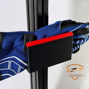 May include: A pair of blue and white racing gloves are held by a black and red holder. The gloves have white accents and a black cuff. The holder is mounted on a black metal support. A logo with the text "XSFSPD 2020" is in the bottom right corner.