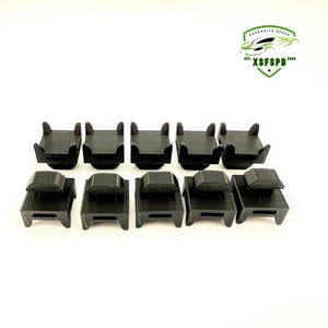 以下が含まれることがあります： 黒いプラスチック製のクリップが10個あり、それぞれ正方形のベースと片側に盛り上がったリップが付いています。クリップは2列5個ずつ配置されています。