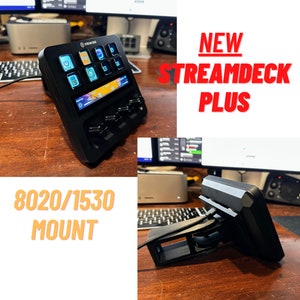 May include: A black Stream Deck Plus with a custom 8020/1530 mount. The Stream Deck Plus has a color LCD screen and multiple buttons. The mount is attached to a desk.