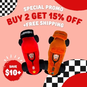 May include: Two plush dog toys shaped like race cars, one red and one orange, with black wheels. Each car has a dog face graphic, the number 8, and the word "Ferrari" or "McLaren" on the top. The image includes text that says "Special Promo" and "Buy 2 Get 15% Off".