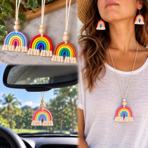 Könnte beinhalten: Eine Sammlung von regenbogenförmigen Ornamenten und Schmuckstücken mit bunten Bögen in Rot, Orange, Gelb, Grün, Blau und Violett. Jedes Stück enthält eine natürliche Holzperle und eine cremefarbene Baumwollfransenquaste, die an einer Kordel hängt.