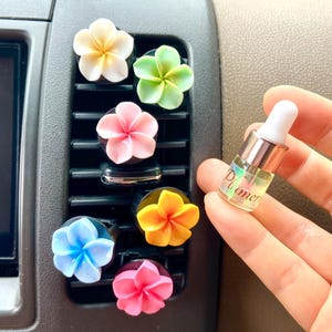 Zestaw 2 dyfuzorów samochodowych o zapachu kwiatu plumerii + 1 mini buteleczka olejku / naturalna mieszanka olejków eterycznych / odświeżacz powietrza do samochodu