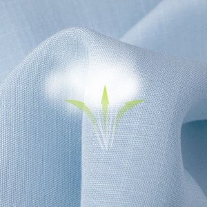 May include: Close-up of light blue fabric with a textured weave. The fabric is gently folded, creating soft shadows and highlights. A graphic of green arrows and a white glow suggest breathability.