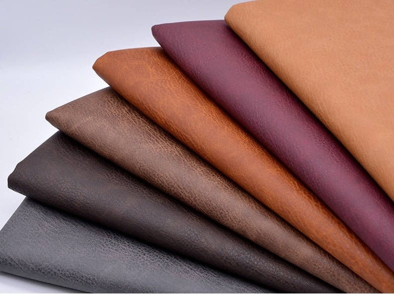 Puede incluir: Una variedad de muestras de tela de imitaci&oacute;n de cuero en diferentes colores, incluyendo marr&oacute;n, gris, marr&oacute;n oscuro y burdeos. Las muestras est&aacute;n dispuestas en forma de abanico, con el color m&aacute;s claro en la parte superior y el color m&aacute;s oscuro en la parte inferior.