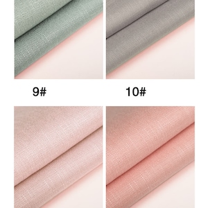 May include: Four fabric swatches in different colors. The swatches are folded in half and show the texture of the fabric. The colors are light green, gray, light pink, and pink.