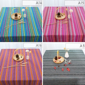 May include: Four different tablecloths with colorful striped and geometric patterns. The tablecloths are made of a woven fabric and have a rustic, bohemian style.