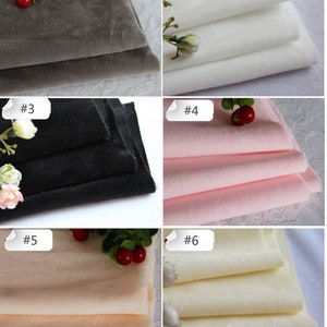 May include: Six fabric swatches in different colors, including gray, white, black, pink, beige, and cream. The swatches are folded and arranged in a grid pattern. Each swatch is labeled with a number from 1 to 6.