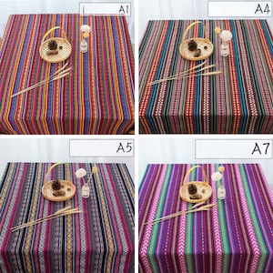 May include: Four different tablecloths with colorful striped patterns. Each tablecloth features a woven design with various colors, including red, blue, green, yellow, and black. The tablecloths are displayed on a white background.