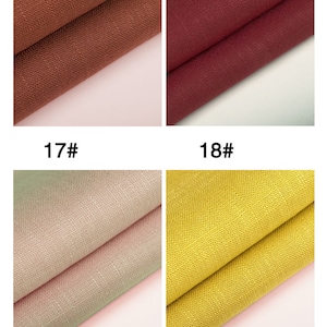 May include: Four fabric swatches in different colors: brown, burgundy, light pink, and yellow. The swatches are folded in half and placed on a light pink background.