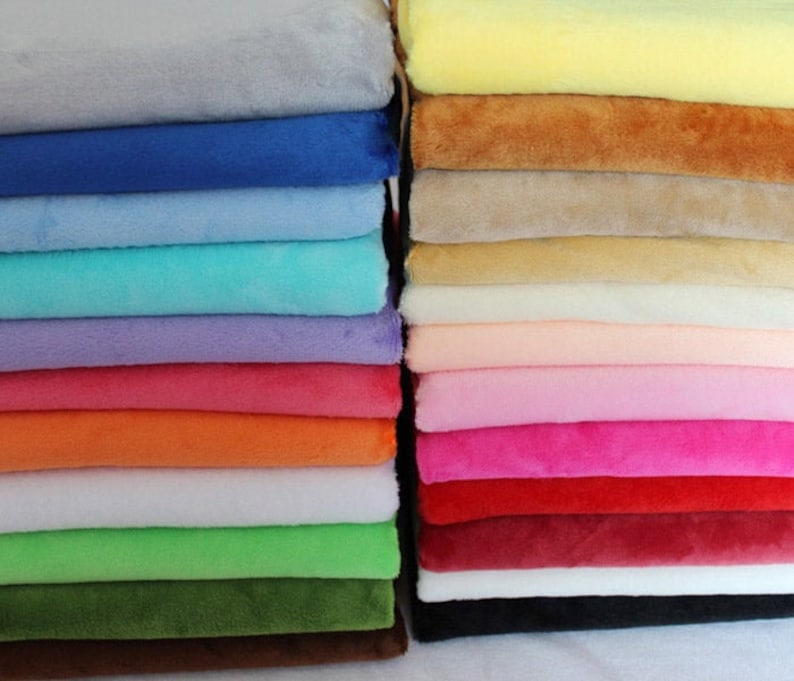 May include: A stack of 20 different colored plush fabrics. The fabrics are arranged in two columns, with 10 fabrics in each column. The fabrics are all soft and fluffy, and they come in a variety of colors, including blue, green, pink, red, and white.