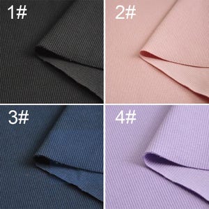May include: Four samples of ribbed fabric in different colors: black, pink, navy blue, and lavender. Each sample is labeled with a number, 1 through 4.