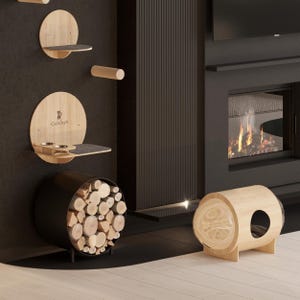 May include: A black metal log holder filled with firewood sits next to a wooden cat bed with a round opening. A fireplace with a roaring fire is in the background. The cat bed has the text "Catsboys" on the side.