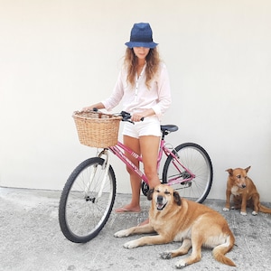 Manillar de la rueda delantera y cesta de una bicicleta femenina cerca de  una puerta de metal marrón