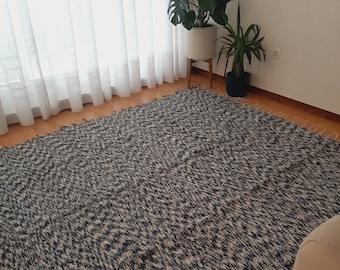 May include: A blue and white patterned rug with a shaggy texture. The rug is laid out on a wooden floor.
